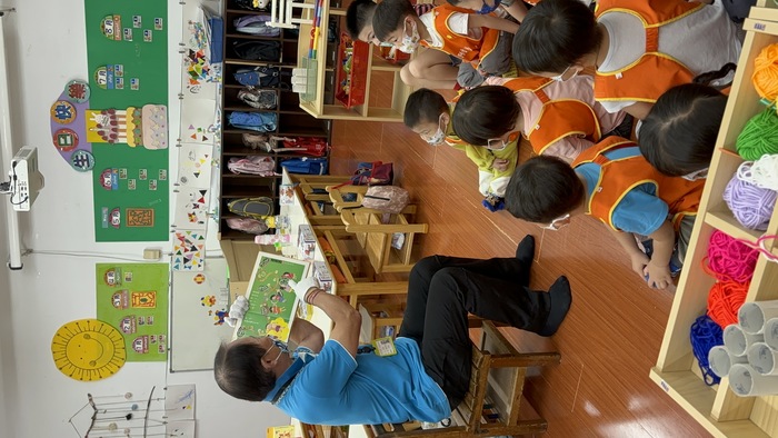 黃爸爸坐著讀繪本給孩子聽